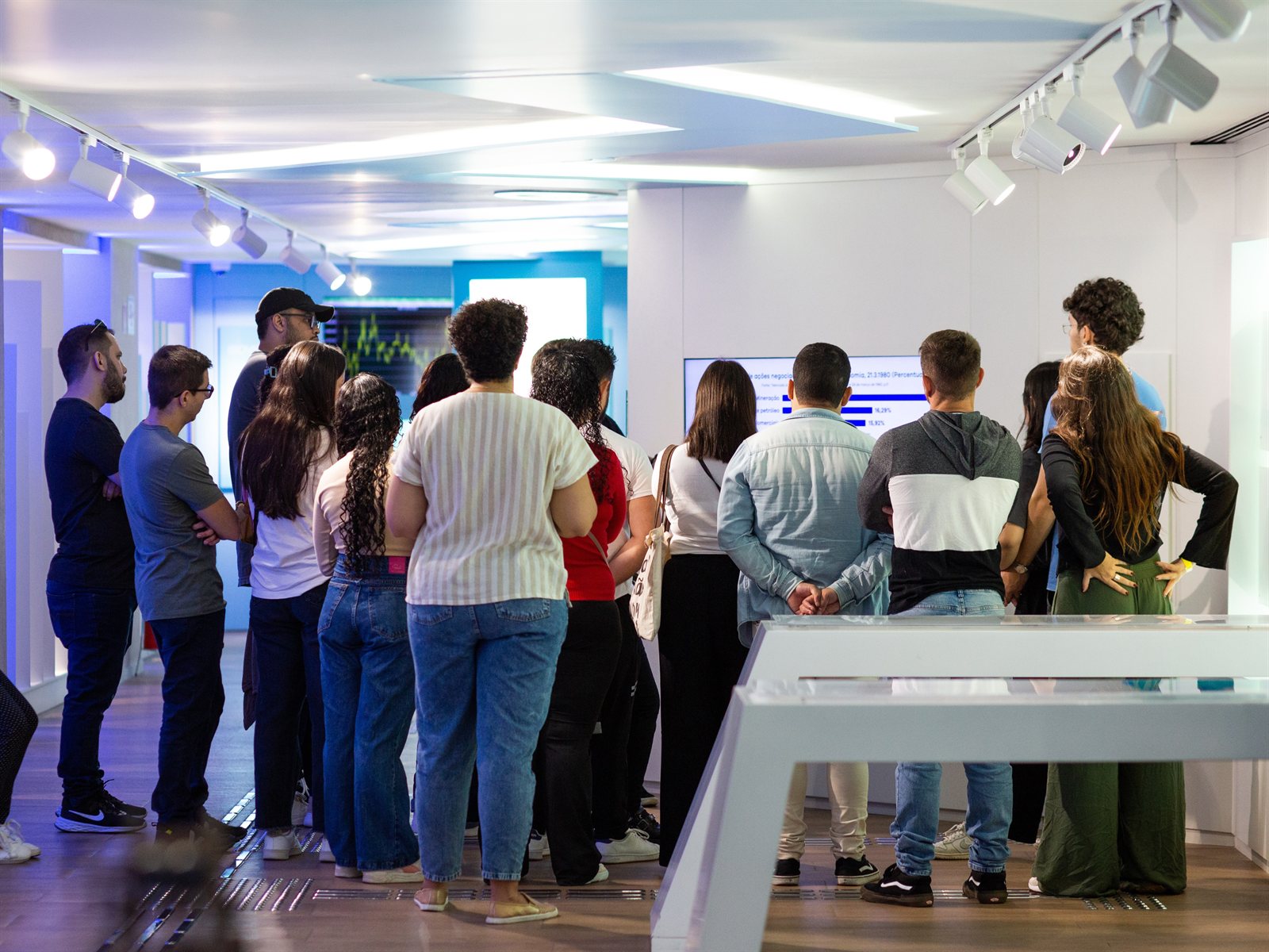 Grupo de visitantes observando um painel da exposição de longa duração do MUB3